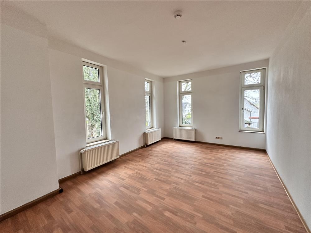 Helleleerer, große Fensterfronten und Parkettboden in einer frisch renovierten Wohnung.